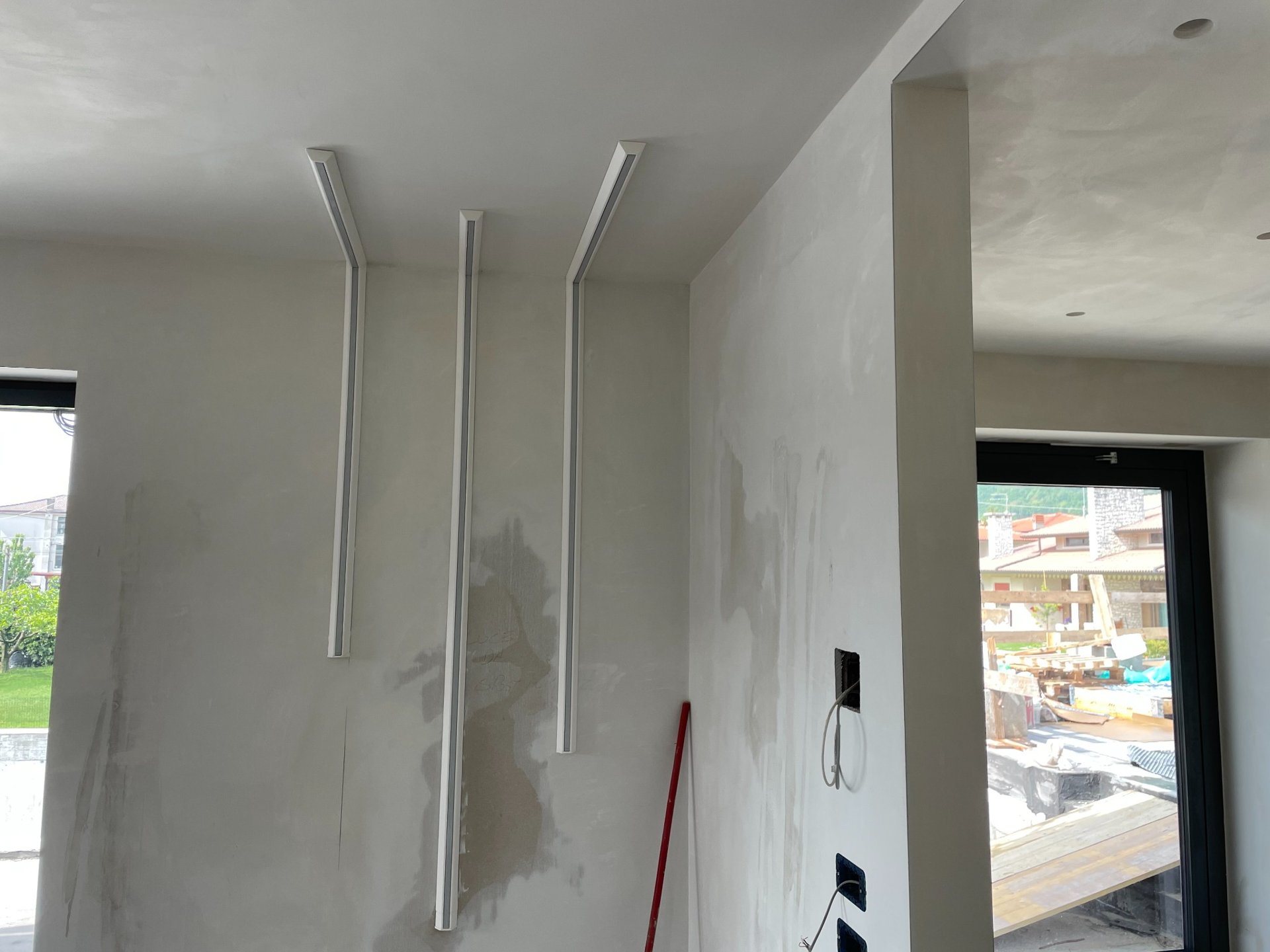 Installazione della Veletta® VME100.2 pronta per incollaggio a soffitto, fase di posa in un’abitazione moderna.